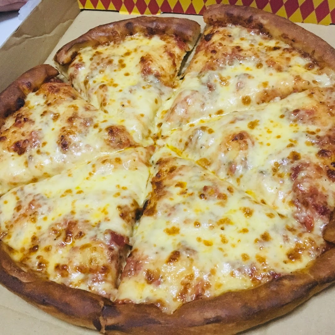 A freshly baked cheese pizza with a thick crust, sliced and ready to eat in a box.