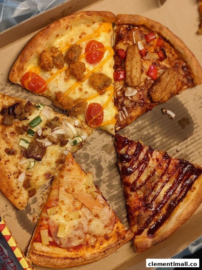 A close-up view of various delicious pizza slices with different toppings in a box.