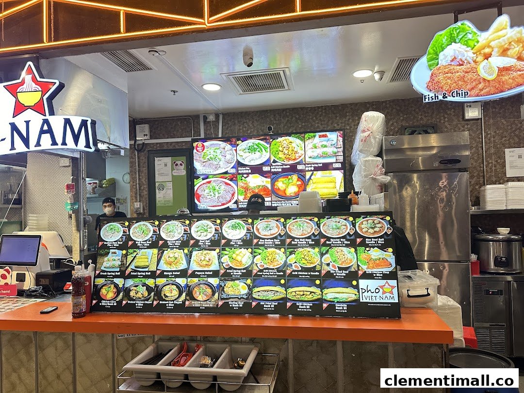 A vibrant food stall counter displaying various Vietnamese dishes and a digital menu.