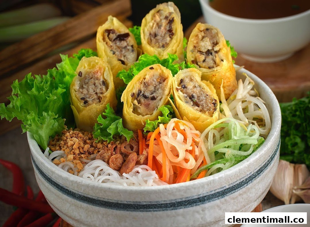 A vibrant bowl of Vietnamese vermicelli noodles with crispy spring rolls and fresh vegetables.