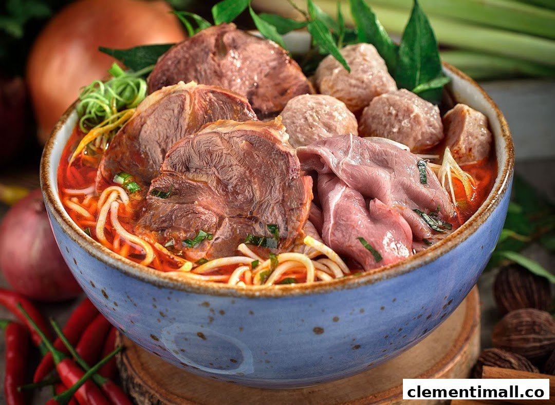 A vibrant bowl of Vietnamese pho with various cuts of beef, meatballs, noodles, and fresh herbs.