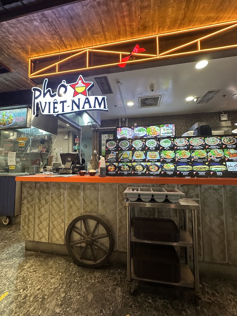 The counter area of Pho Vietnam, featuring its illuminated sign and digital menu displays.