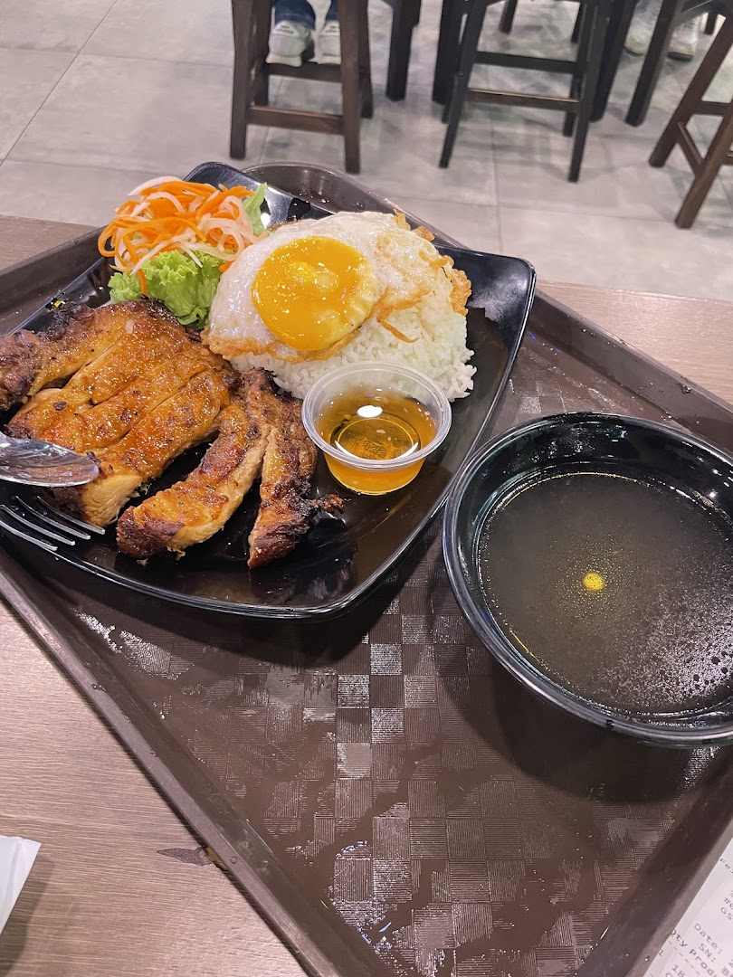A delicious plate of Vietnamese grilled chicken rice with a fried egg, salad, and soup.