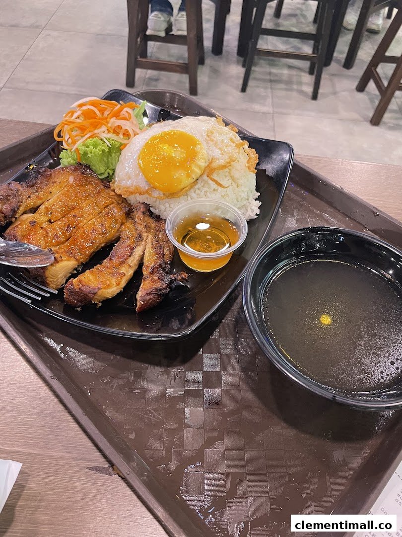 A delicious plate of Vietnamese grilled chicken rice with a fried egg, salad, and soup.