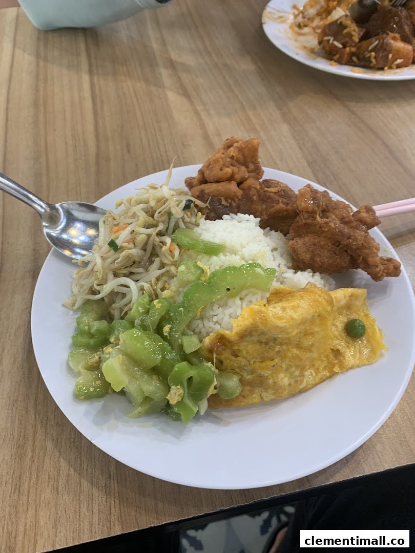 A delicious plate of rice with fried chicken, stir-fried vegetables, and an omelette.