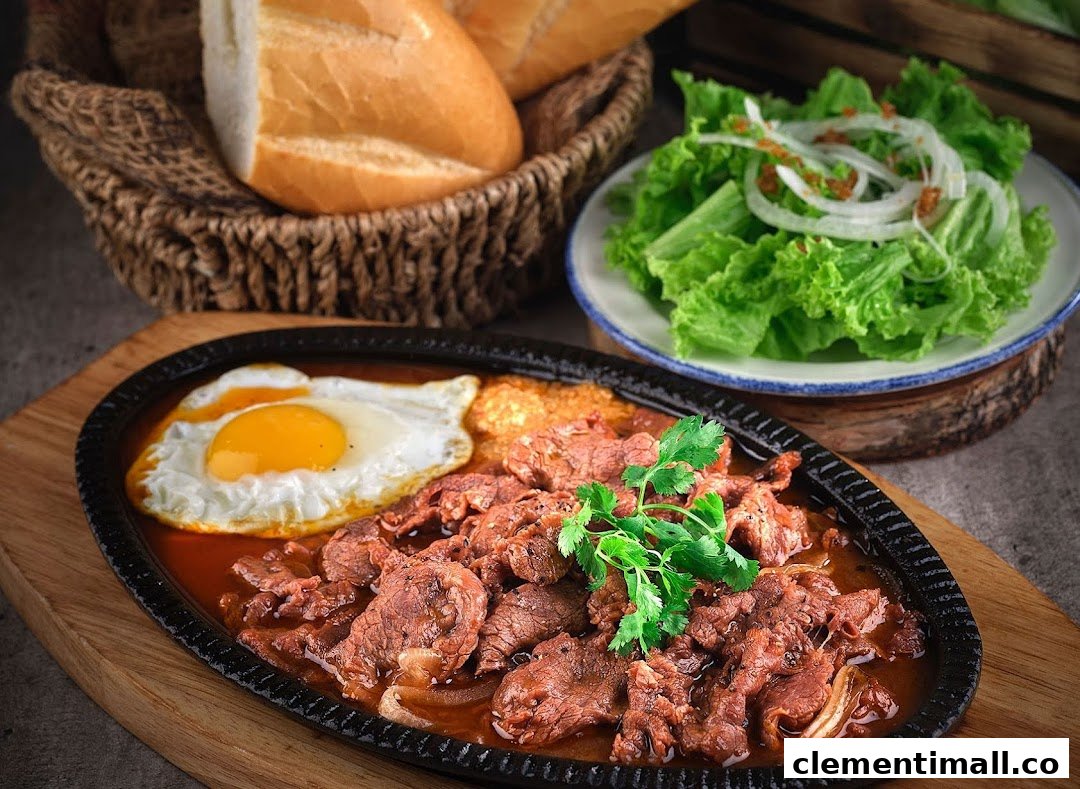 A sizzling plate of Vietnamese beef with fried eggs, served with fresh bread and salad.