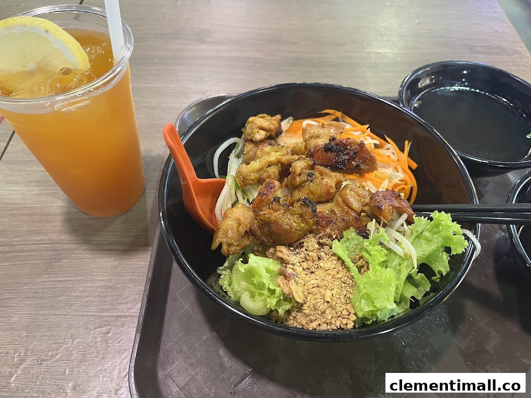 A delicious bowl of Vietnamese grilled chicken noodles with fresh vegetables and a refreshing iced tea.