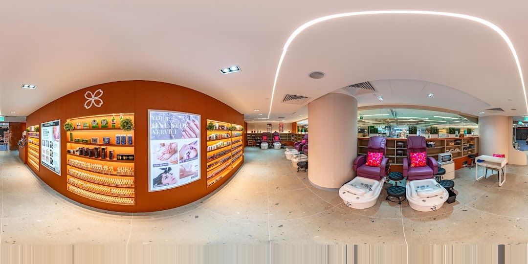 A panoramic view of Pixie Nail Spa's interior, showcasing nail polish displays and comfortable pedicure stations.