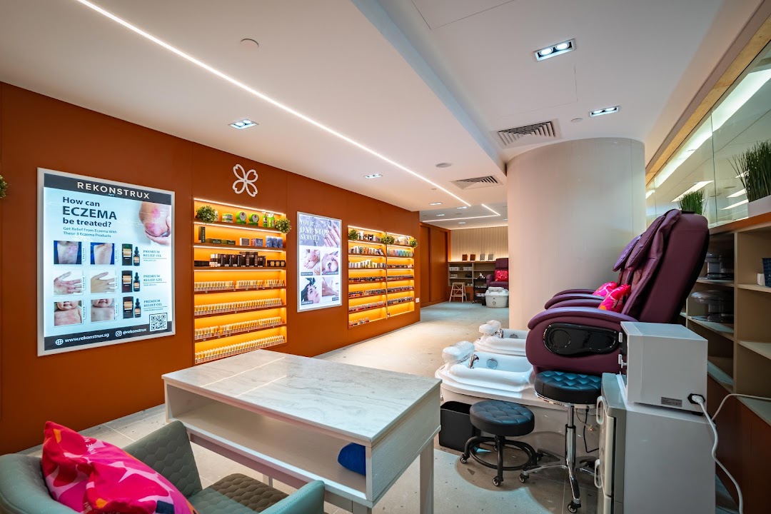 An inviting interior of a modern nail spa featuring pedicure chairs and product displays.