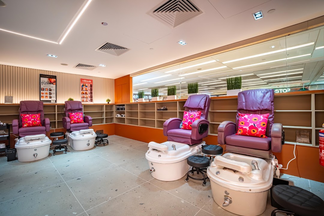 Interior view of Pixie Nail Spa showing comfortable purple pedicure chairs and foot baths.