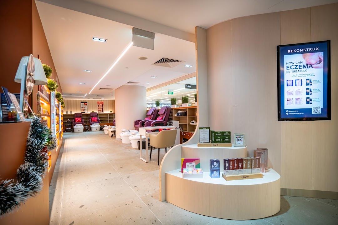 Interior view of a modern nail spa featuring comfortable pedicure stations and product displays.