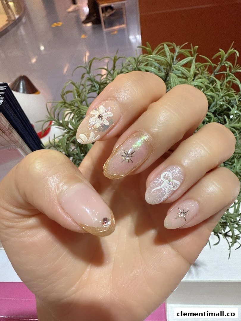 A hand showcasing beautifully manicured nails with intricate designs, glitter, and embellishments.