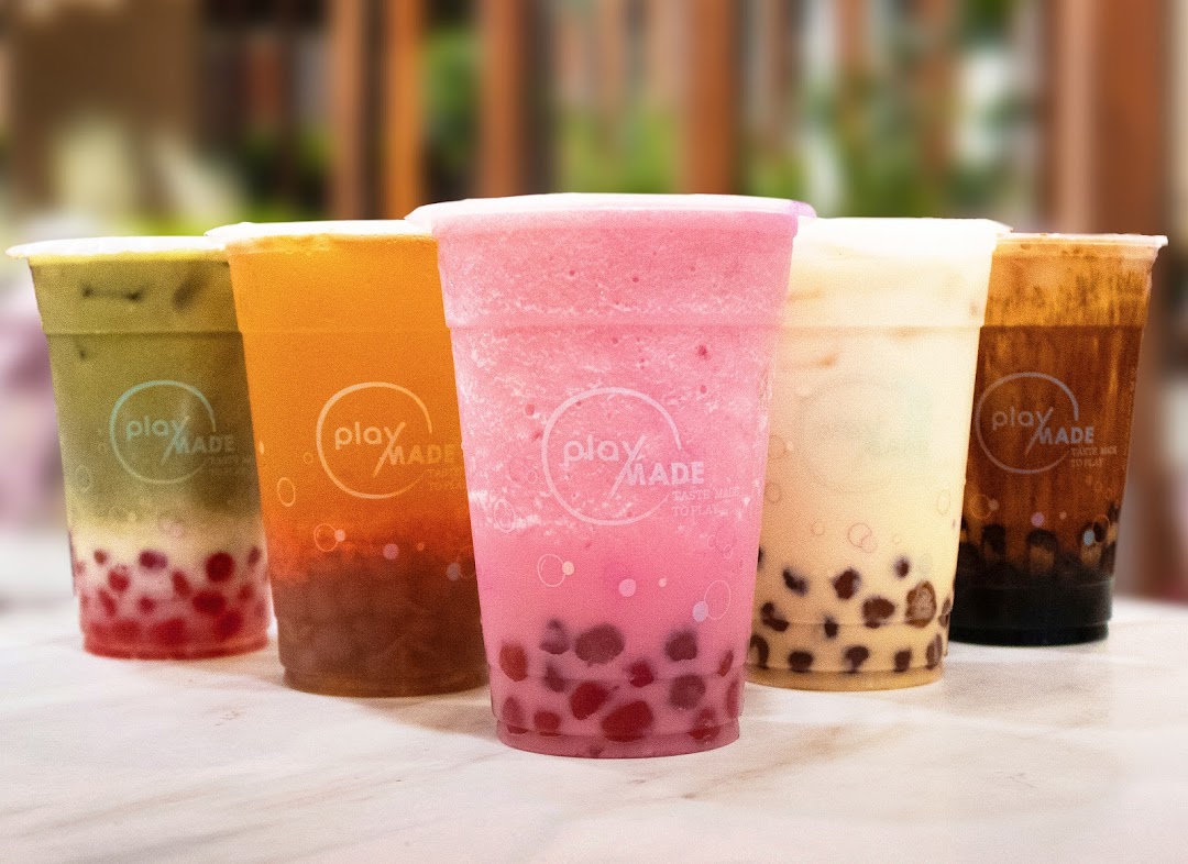 Five colorful bubble tea drinks from PlayMade are displayed on a counter.