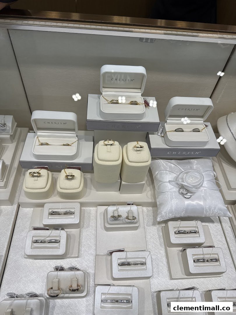 A display case showcasing various rings, necklaces, and a white wedding ring pillow.