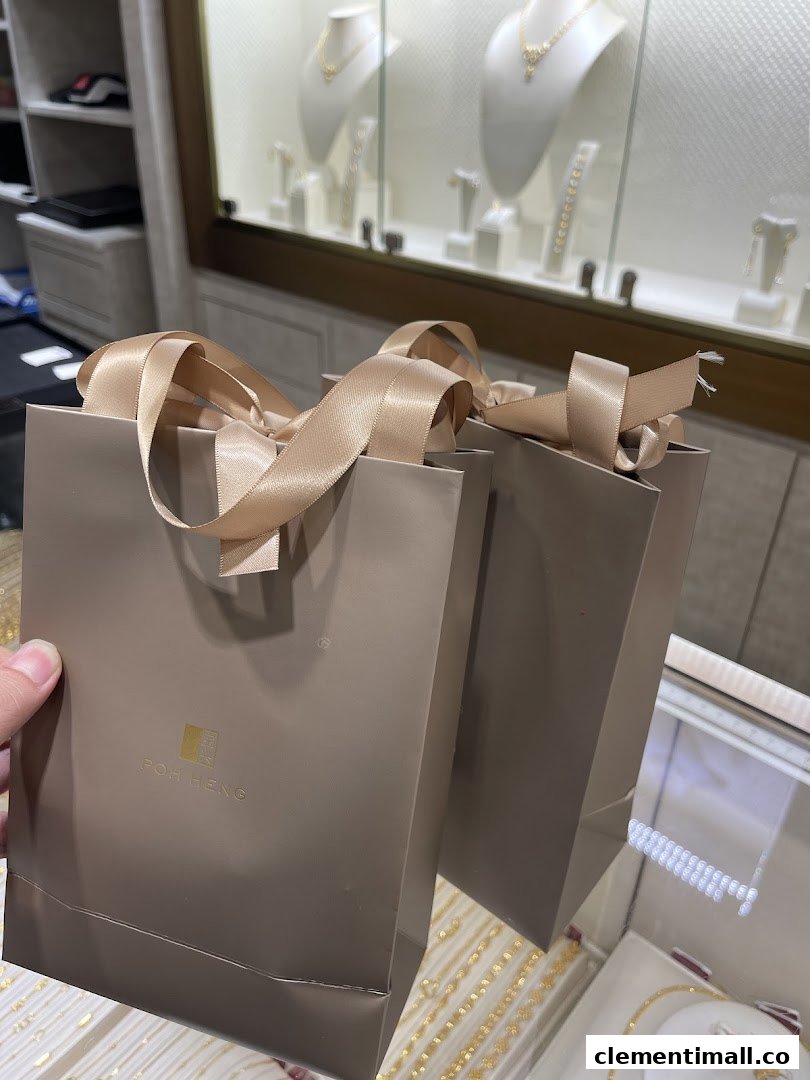 Two Poh Heng shopping bags with gold jewellery displays visible in the background.