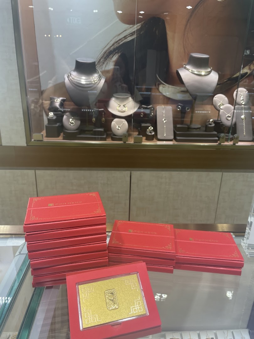 A display of exquisite gold jewellery and gold bars in red packaging at Poh Heng Jewellery.
