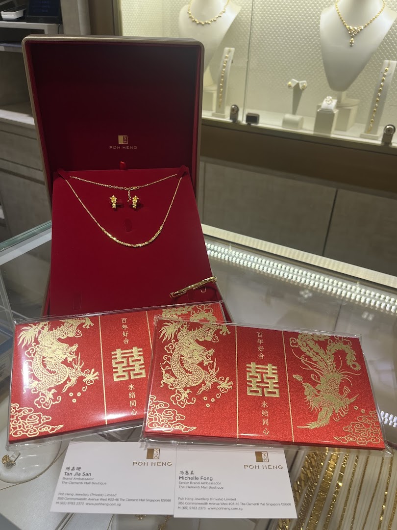 A gold necklace and earrings set in a red velvet box, accompanied by traditional red packets, displayed in a jewelry store.
