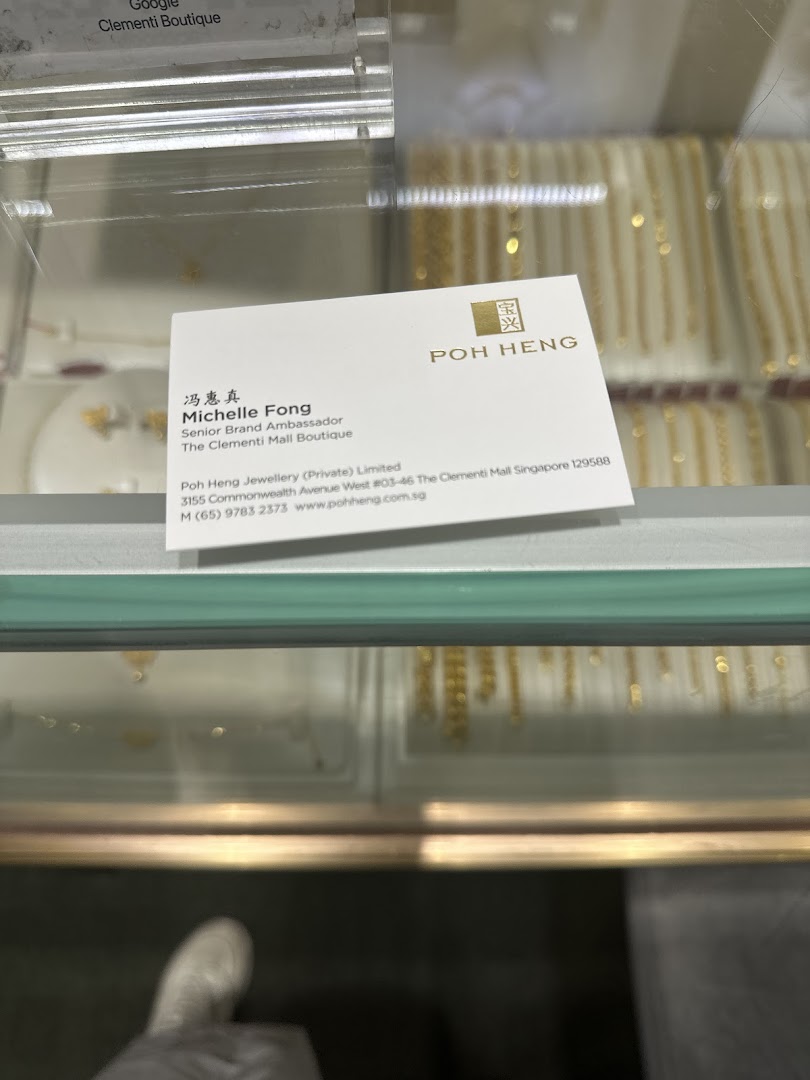 A business card for Poh Heng Jewellery displayed within a jewellery showcase.