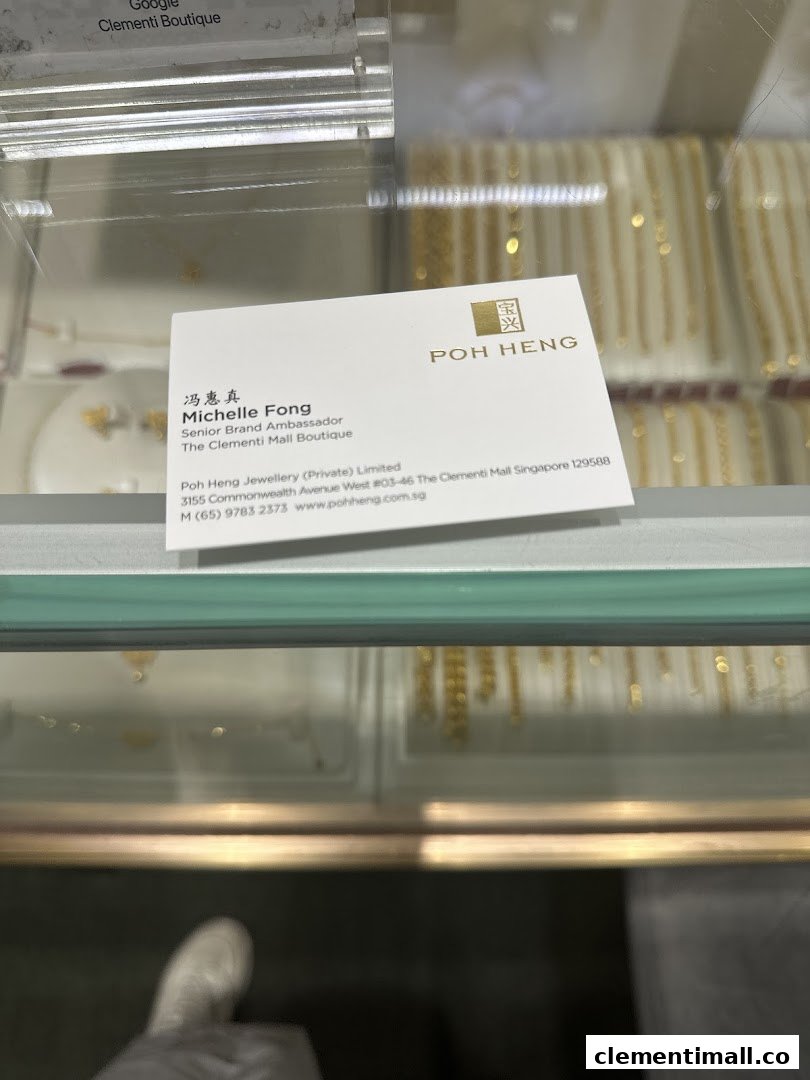 A business card for Poh Heng Jewellery displayed within a jewellery showcase.