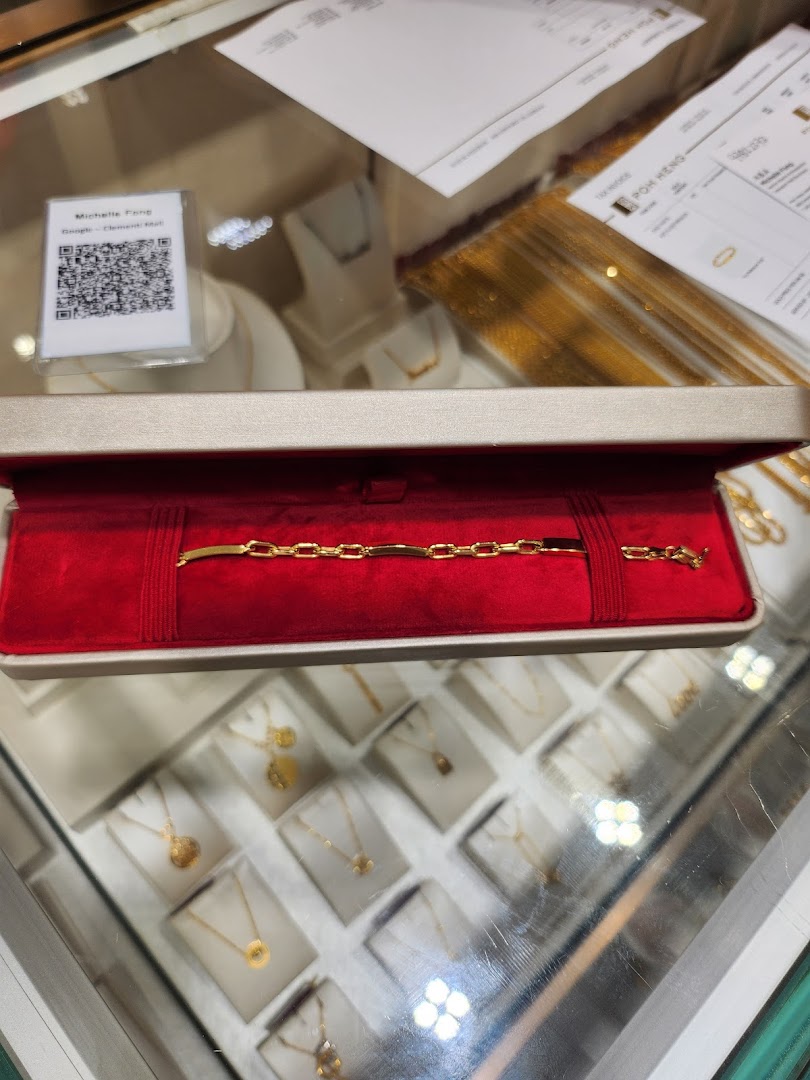 A gold bracelet displayed in a red velvet box inside a jewellery store.