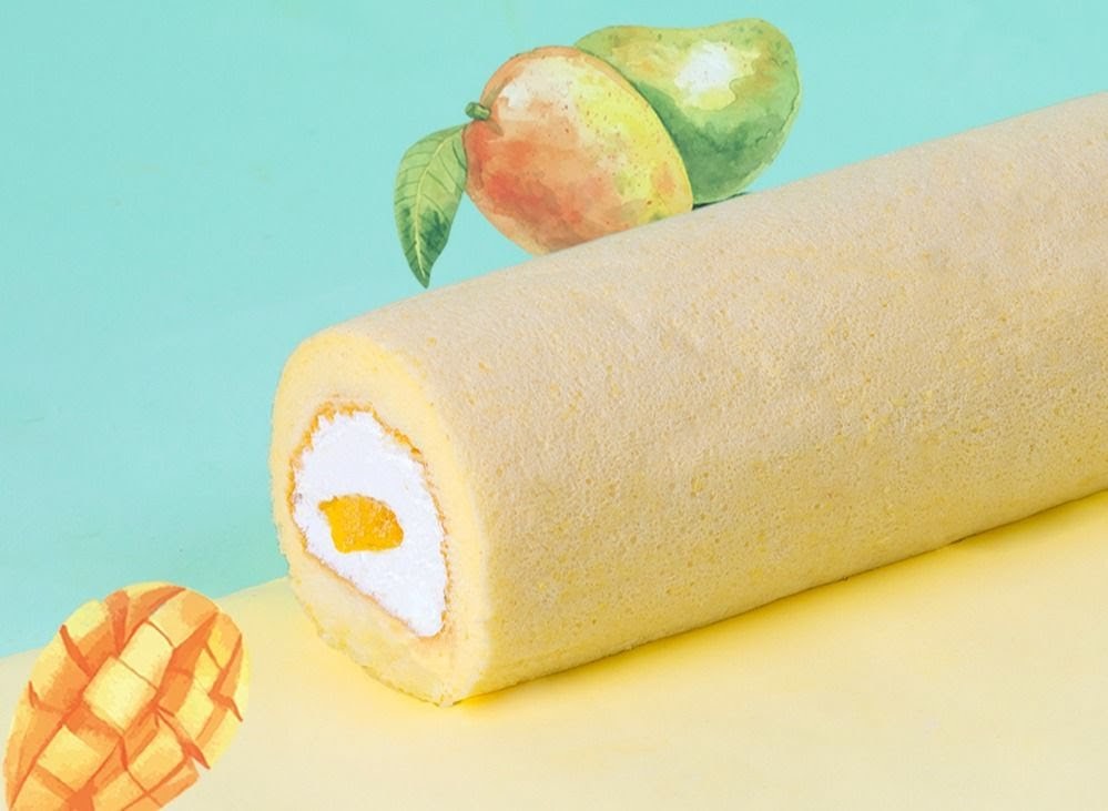 A close-up of a mango swiss roll with cream filling, set against a colorful background with mango illustrations.