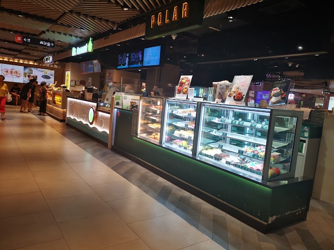 A vibrant bakery counter at Polar Puffs & Cakes, showcasing a variety of delicious pastries and cakes.