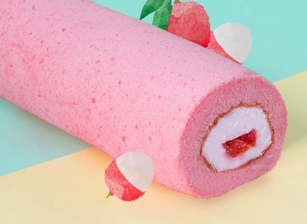 A vibrant pink swiss roll with creamy filling and fruit pieces, adorned with lychee illustrations.