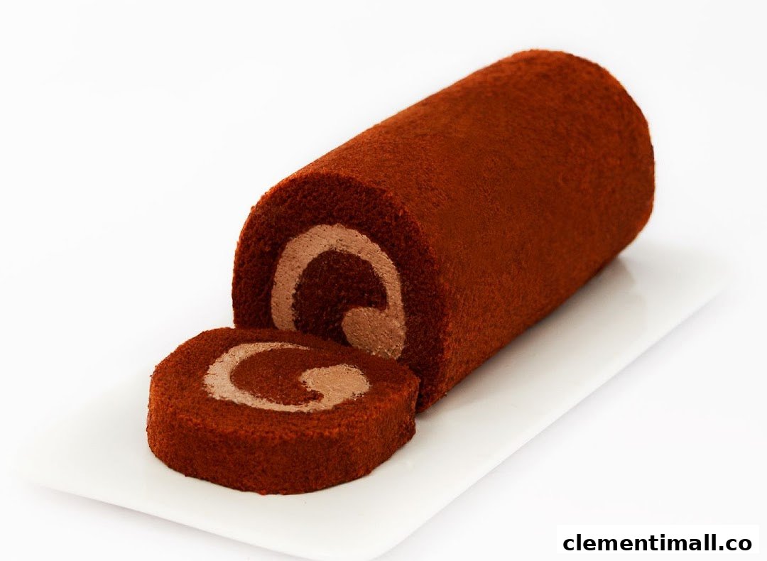 A chocolate cake roll with a slice cut off, revealing creamy filling on a white plate.