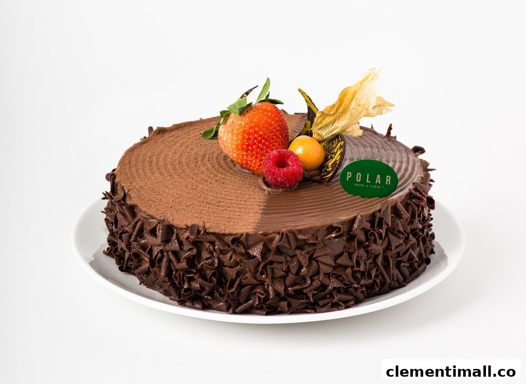 A decadent chocolate cake adorned with fresh berries and a Polar Puffs & Cakes logo.