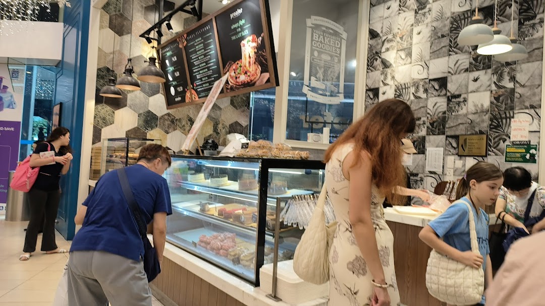 Customers browse a display of fresh baked goods and cakes inside Proofer Boulangerie.