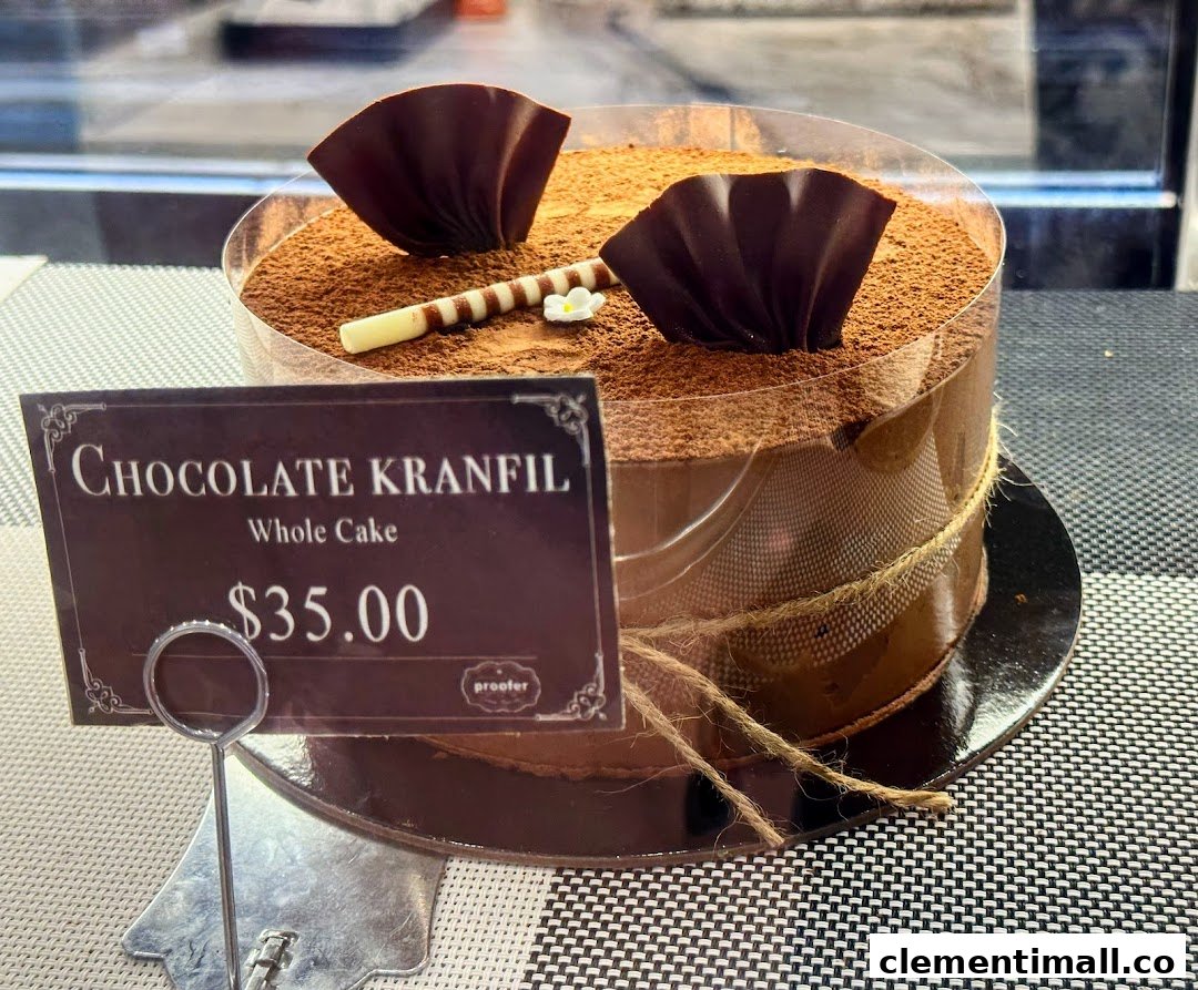 A decadent Chocolate Kranfil whole cake with chocolate decorations and a price tag displayed.