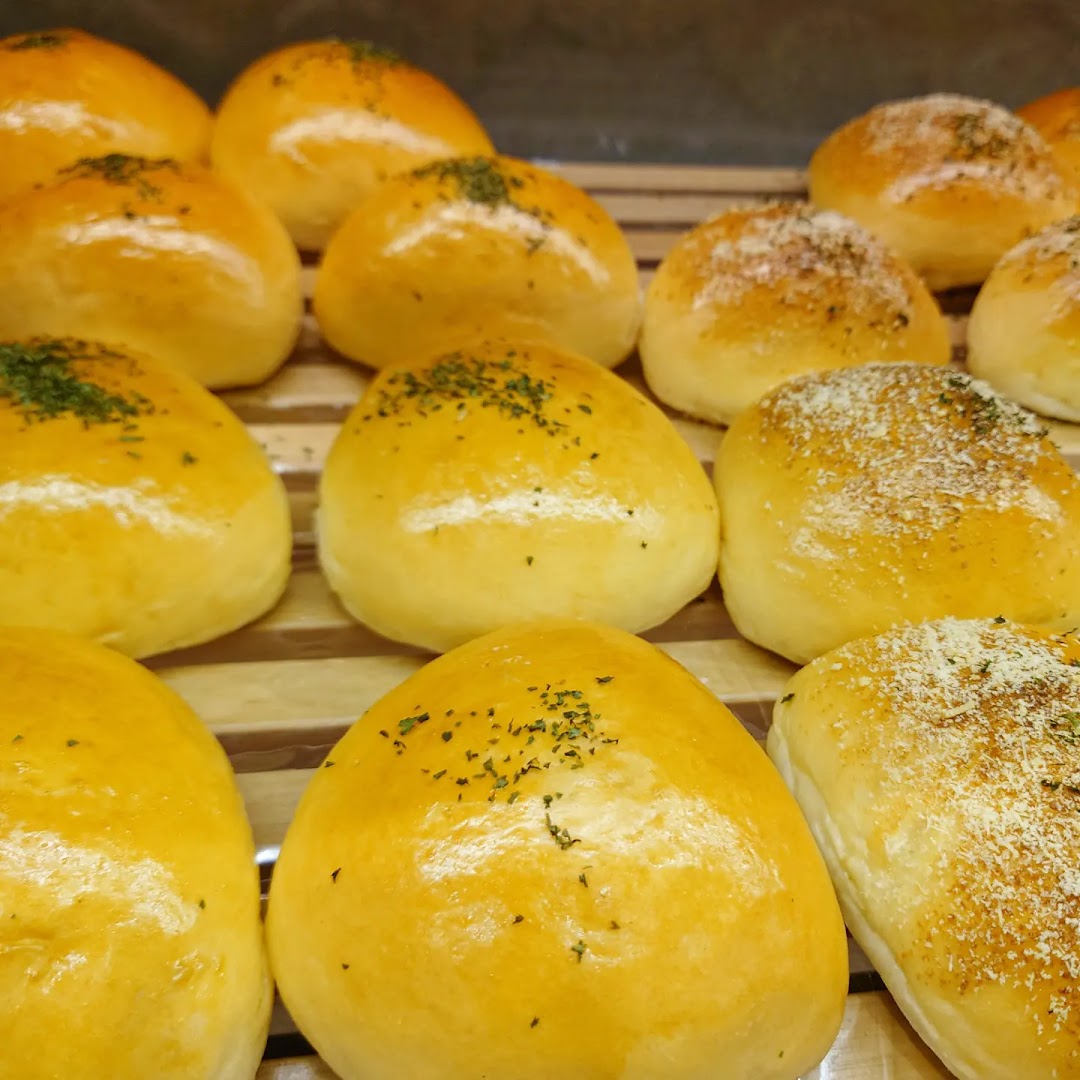 Close-up of freshly baked golden buns, some topped with herbs and others with a savory sprinkle.
