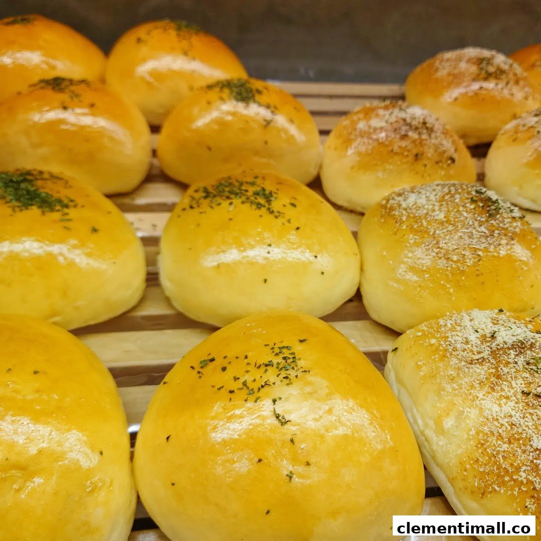 Close-up of freshly baked golden buns, some topped with herbs and others with a savory sprinkle.