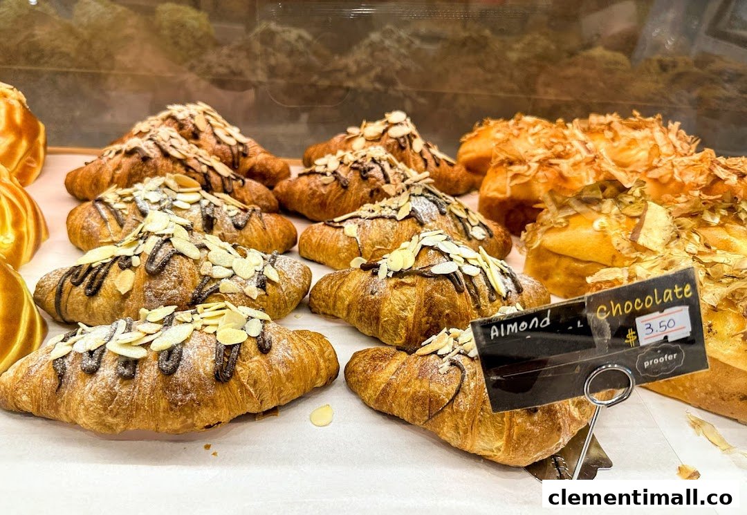 A display of freshly baked chocolate almond croissants and other golden pastries at Proofer Boulangerie.