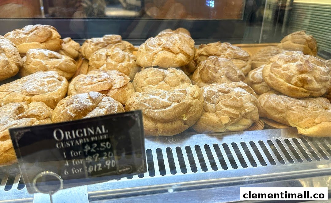 A display case filled with freshly baked Original Custard Puffs, showing their pricing.