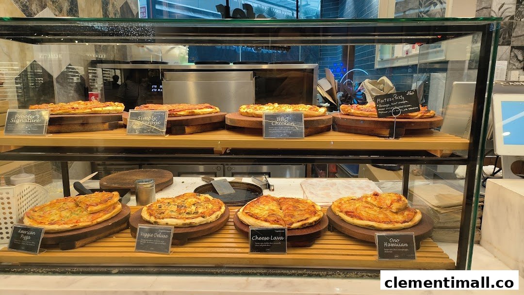 A glass display case filled with various freshly baked pizzas and flatbreads on wooden stands.