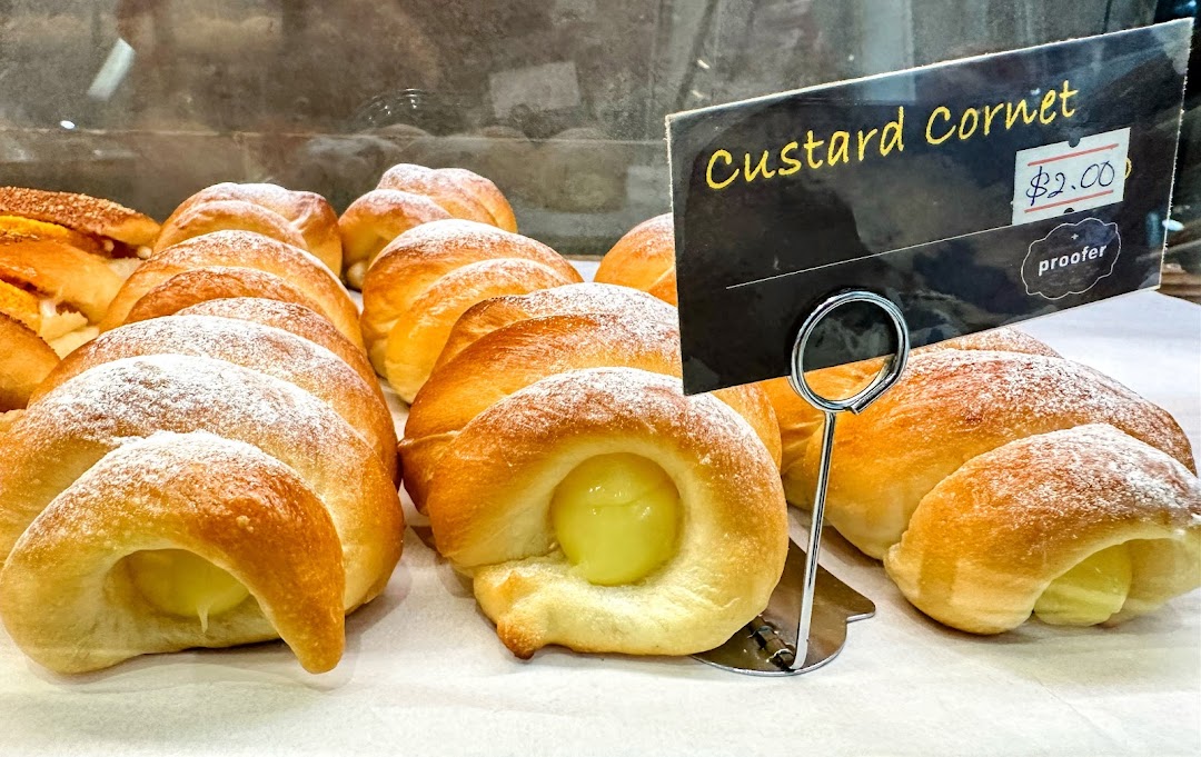 A display of freshly baked Custard Cornets, dusted with powdered sugar, at Proofer Boulangerie.