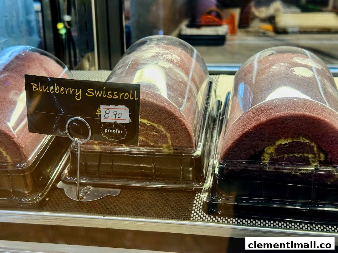 Close-up of blueberry swiss rolls displayed in a bakery showcase with a price tag.