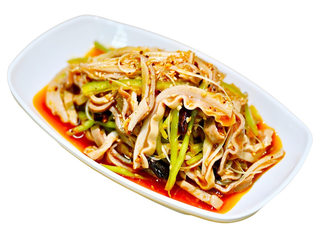 A spicy cold dish featuring sliced tripe, green vegetables, and sesame seeds in a red sauce.