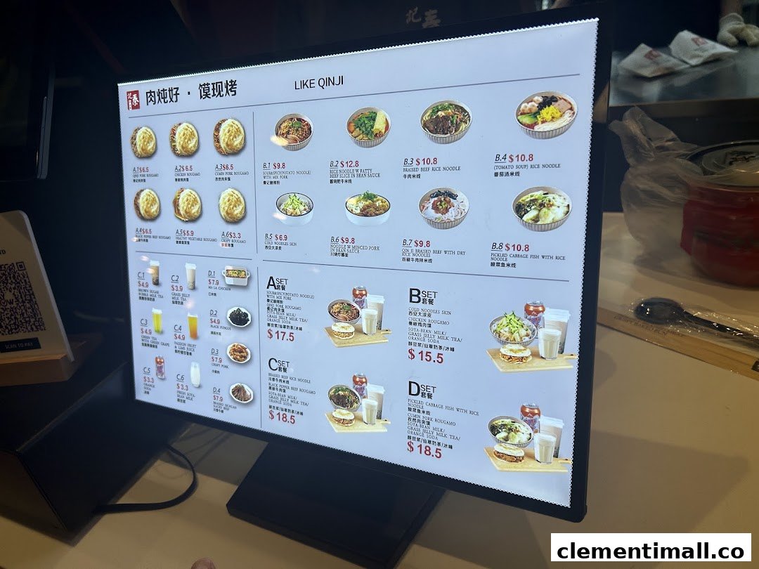 A brightly lit digital menu board displaying various Chinese dishes and drinks with prices.
