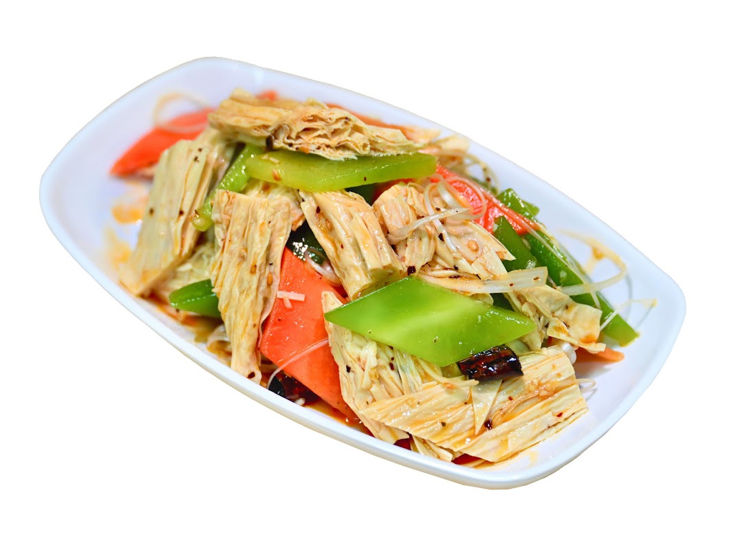 A vibrant cold appetizer featuring tofu skin, green peppers, and carrots in a savory sauce.
