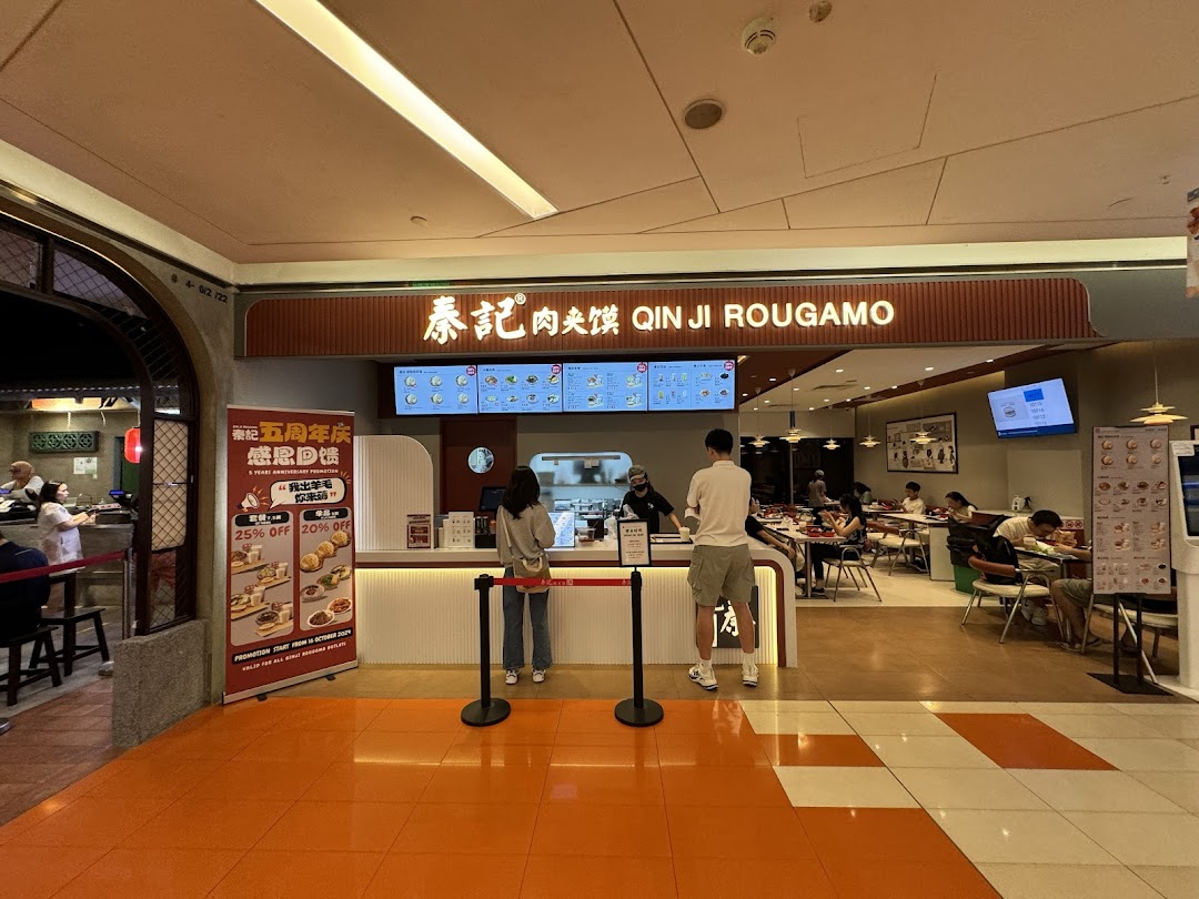 The shopfront of Qin Ji Rougamo, featuring its entrance, counter, and customers dining inside.