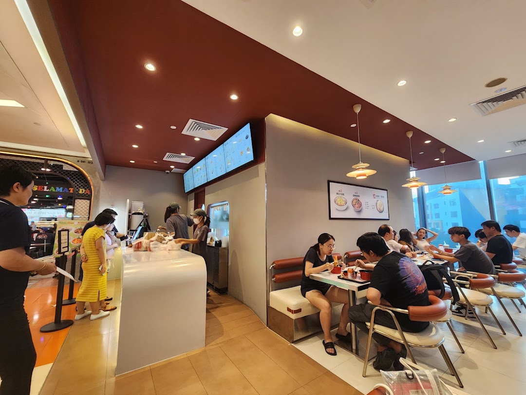 Customers dine and order at Qin Ji Rougamo, showcasing a bustling interior with modern decor.