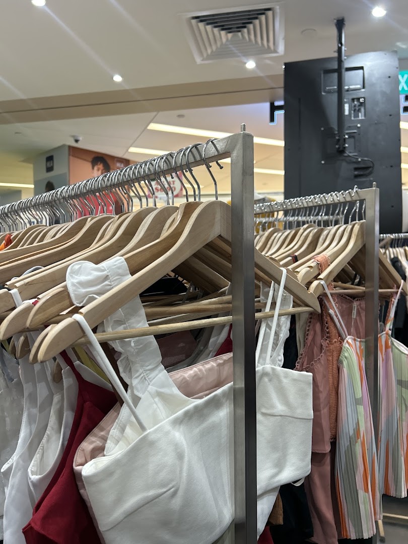 A close-up view of various pre-loved fashion items displayed on hangers inside REFASH.