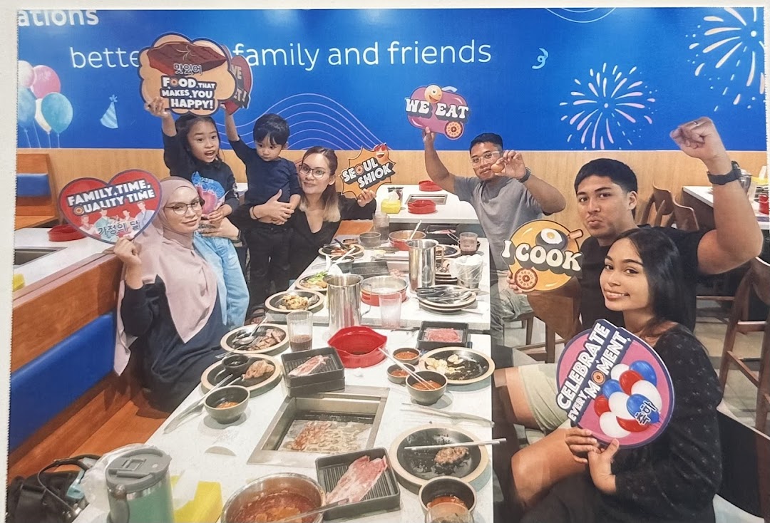 A lively group of friends and family enjoying a Korean BBQ and hotpot meal at Seoul Garden.