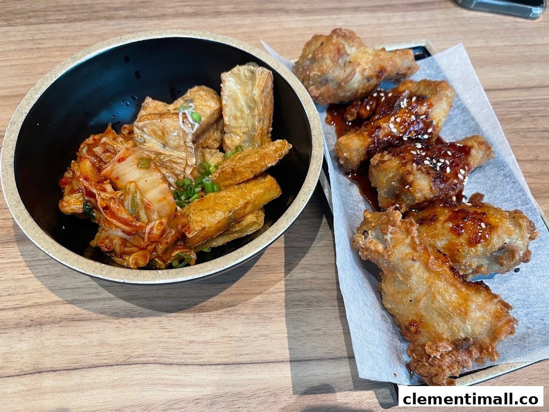 A delicious spread featuring kimchi with fried tofu skin and crispy Korean fried chicken wings.