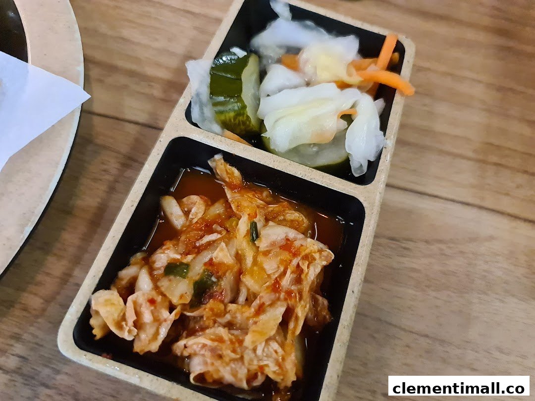A close-up of traditional Korean banchan, including kimchi and pickled vegetables, served in a divided dish.