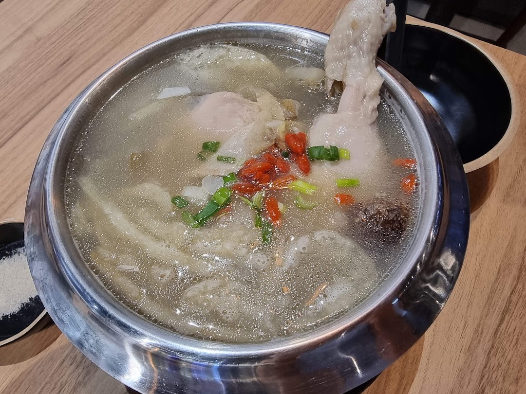 A hearty pot of traditional Korean ginseng chicken soup (Samgyetang) with goji berries and spring onions.
