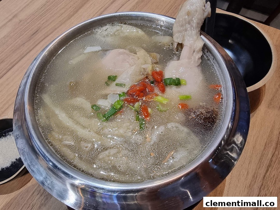 A hearty pot of traditional Korean ginseng chicken soup (Samgyetang) with goji berries and spring onions.