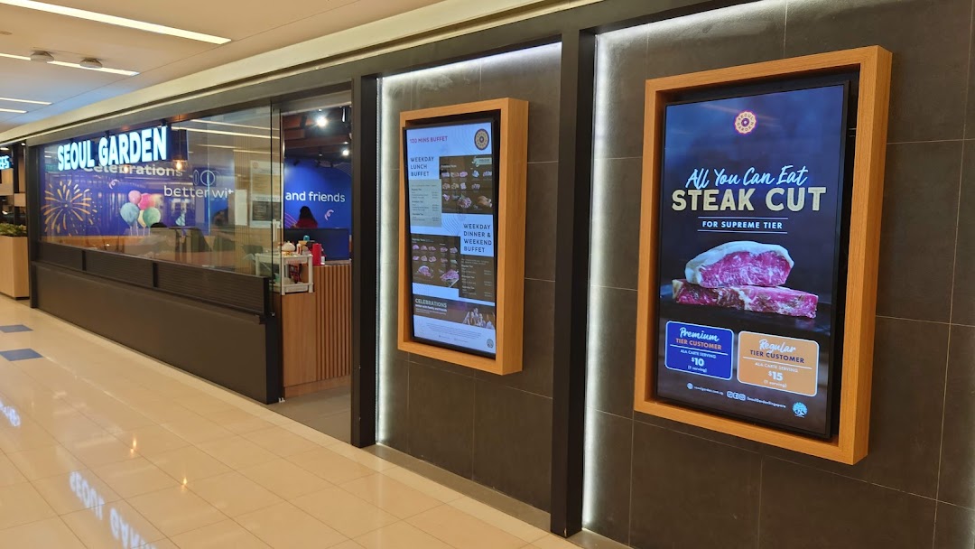 The entrance of Seoul Garden showcasing digital displays with buffet and all-you-can-eat steak promotions.